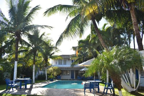 une maison avec une piscine et des palmiers dans l'établissement Hibiscus Center, à Búzios