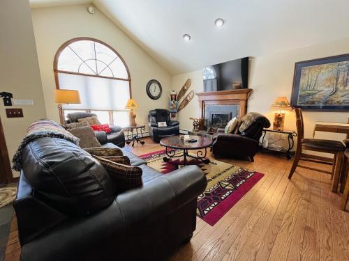 a living room with a leather couch and a table at Heavenly Pines -- EV #3361 home in Estes Park