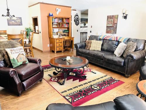 a living room with leather furniture and a table at Heavenly Pines -- EV #3361 home in Estes Park