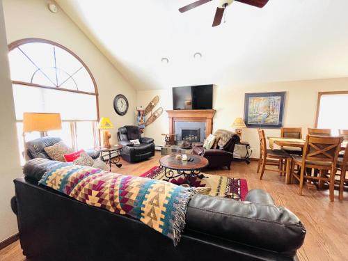 a living room with a leather couch and a table at Heavenly Pines -- EV #3361 home in Estes Park