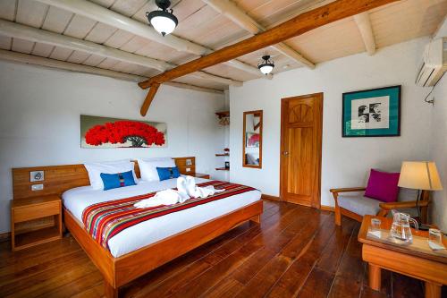 a bedroom with a large bed and a table at Enchanted Galapagos Lodge in Puerto Ayora
