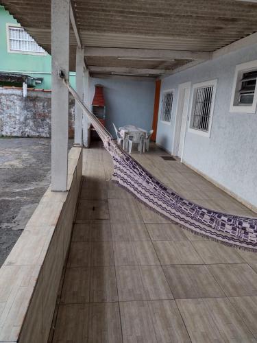 a porch with a hammock in a building at Fala Mansa in Itanhaém