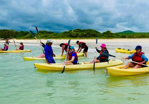 a group of people in kayaks in the water at Enchanted Galapagos Lodge in Puerto Ayora