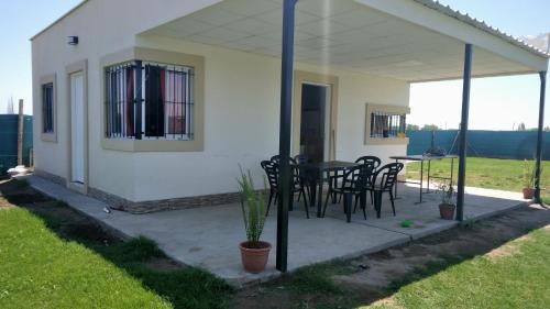 a house with a patio with chairs and a table at Casa con piscina in Maipú