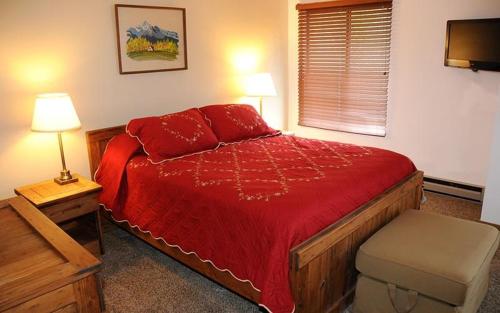 um quarto com uma cama vermelha e uma janela em Seven Springs Swiss Mountain 3 Bedroom Standard Condo, Sleeps 8! condo em Champion