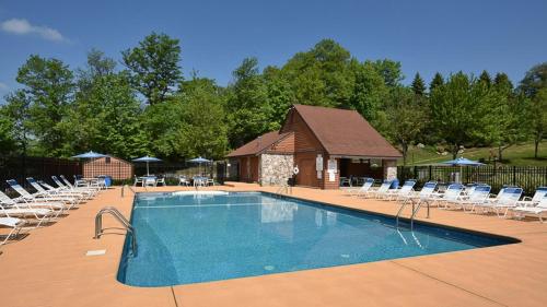 a large swimming pool with chairs and a building at Seven Springs Swiss Mountain 3 Bedroom Standard Condo, Sleeps 8! condo in Champion