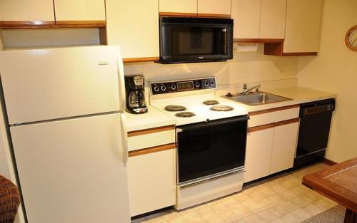 a kitchen with a white refrigerator and a sink at Seven Springs Swiss Mountain 1 Bedroom Standard Condo condo in Champion