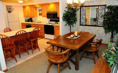 a kitchen with a wooden table and some chairs at Seven Springs Deluxe Condo near Pool in Champion