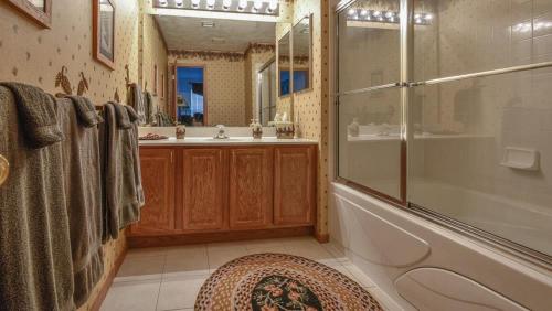 a bathroom with a shower and a tub and a sink at Seven Springs Woodridge 4 Bedroom Premium Condo, Deck with Mountain Views condo in Champion