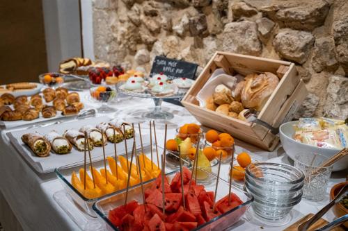 a buffet of food with fruit and pastries on a table at Palazzo Gilistro in Siracusa