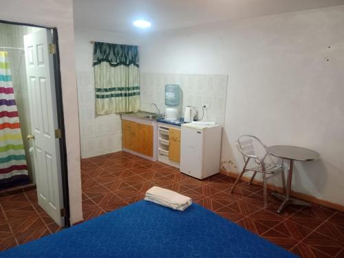 cocina pequeña con mesa y suelo azul en Habitación sol naciente peuco, en Calama