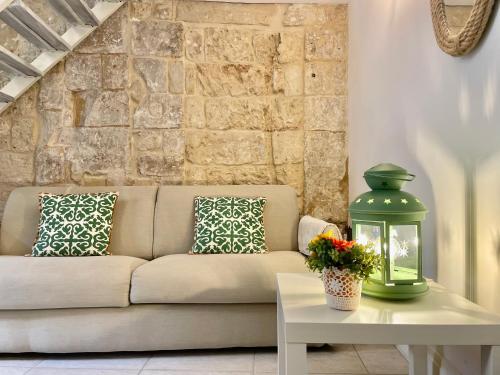 a living room with a couch and a table with a lantern at Nohi's House in the historic center in Lecce