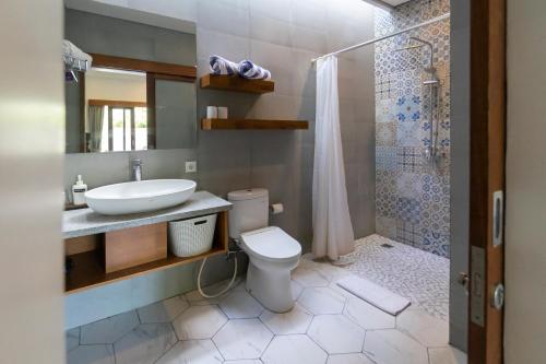 uma casa de banho com um WC, um lavatório e um chuveiro em Asanaya Suites em Canggu