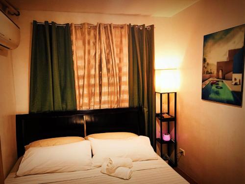 a bedroom with a bed with a window and a bedspread at One Oasis Condominium in Davao City