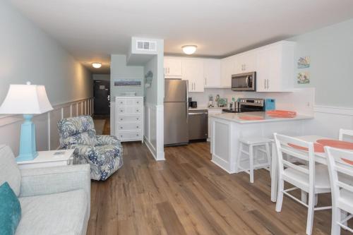 a kitchen and living room with a couch and a table at 0606 Endless Summer by Atlantic Towers in Carolina Beach