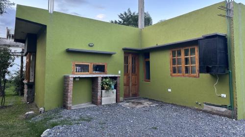 una casa verde con puerta y ventana en La Pichonita en Lozano