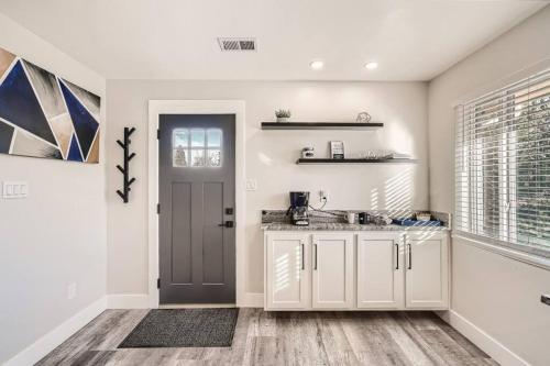 une cuisine avec des placards blancs et une porte dans l'établissement NEW Luxurious Modern Space just West of Denver, à Wheat Ridge