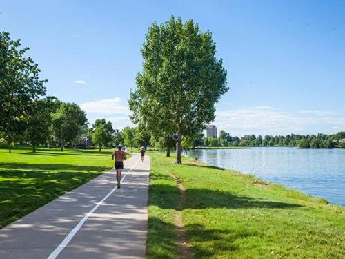 a person running on a path next to a lake at NEW Luxurious Modern Space just West of Denver in Wheat Ridge