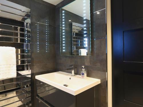 ein Badezimmer mit Waschbecken und Spiegel in der Unterkunft Harbour Cottage in Dartmouth