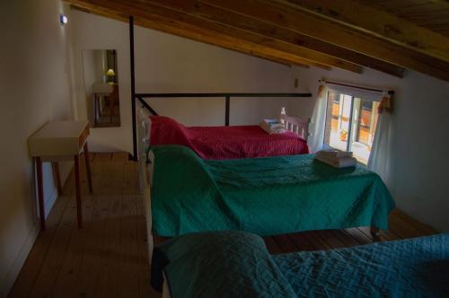 a bedroom with a green bed and a window at Los Ñires in Esquel