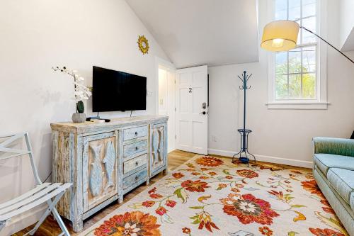 a living room with a tv on top of a dresser at Julia Whitehead Guest Suites in Key West