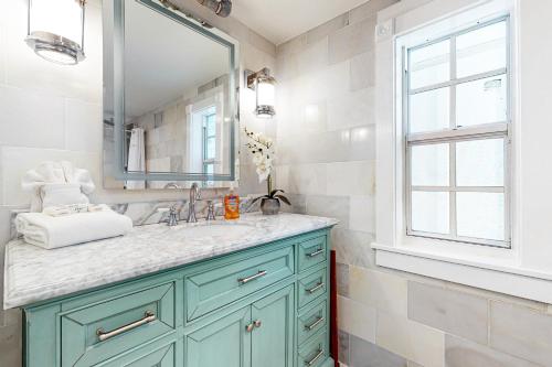 a bathroom with a blue cabinet and a mirror at Julia Whitehead Guest Suites in Key West