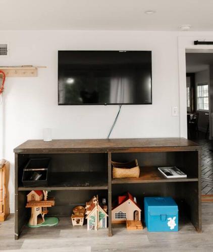 a television on top of a shelf with toy houses at Ode to the '70's creative private home with pool in Honey Brook