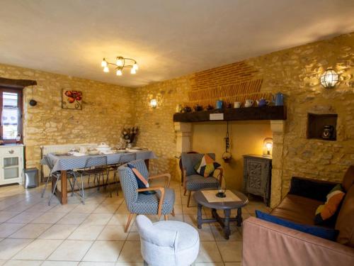 un salon avec un canapé et une table avec des chaises dans l'établissement Maison de caractère avec jardin, proche rivière, équipements enfants, à 3 km du Bugue - FR-1-616-176, à Limeuil