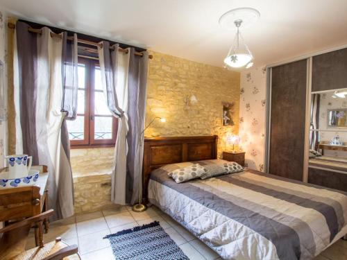 a bedroom with a bed and a stone wall at Maison de caractère avec jardin, proche rivière, équipements enfants, à 3 km du Bugue - FR-1-616-176 in Limeuil