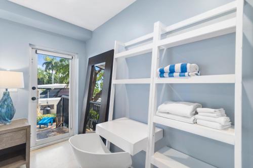 a bathroom with a white shelving unit with towels at Isle of Venice Residence and Marina in Fort Lauderdale