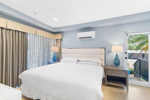 Un dormitorio con una gran cama blanca y una ventana en Isle of Venice Residence and Marina, en Fort Lauderdale