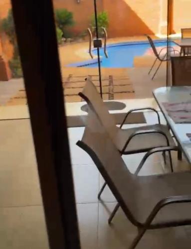 una mesa y sillas frente a una piscina en Casa hotel en Encarnación