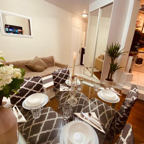 un salon avec une table, des chaises et un canapé dans l'établissement Paris parc Buttes-Chaumont, à Paris