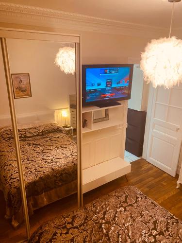 - une chambre avec une télévision et un lit dans un miroir dans l'établissement Paris parc Buttes-Chaumont, à Paris