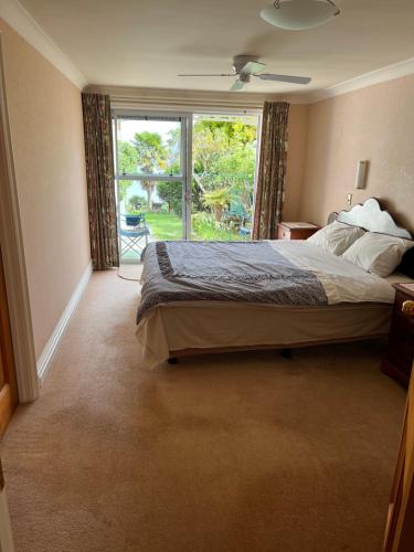a bedroom with a bed and a large window at Tamaterau Seaview House in Whangarei in Whangarei