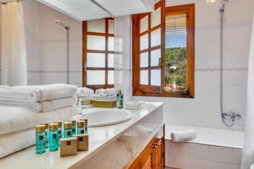 y baño con lavabo, bañera y espejo. en Villa Enri Dreamy Vacation Home Pool Jacuzzi, en Parcent