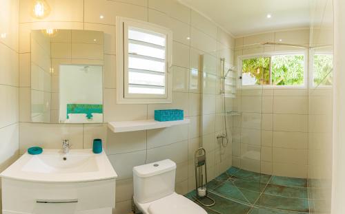 La salle de bains est pourvue de toilettes, d'un lavabo et d'une fenêtre. dans l'établissement FARE VAVAE, à Tevaitoa