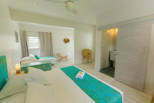 Un dormitorio con cama y escritorio y una habitación con lavabo. en FARE VAVAE en Tevaitoa