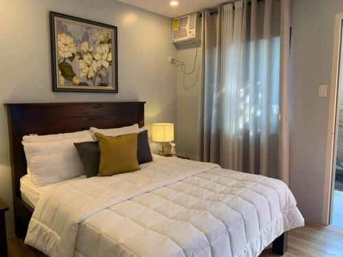 een slaapkamer met een groot wit bed en een raam bij The Great Molave FAMILY ROOM in Cavite