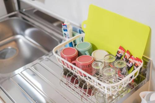 a basket of dishes and cups in a dishwasher at 難波南52 in Osaka
