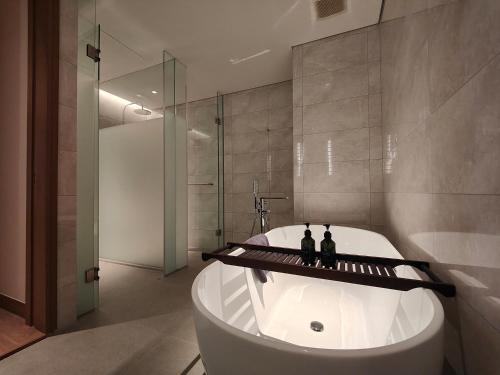 a bathroom with a tub with two bottles on it at Ra Suites Simatupang in Jakarta