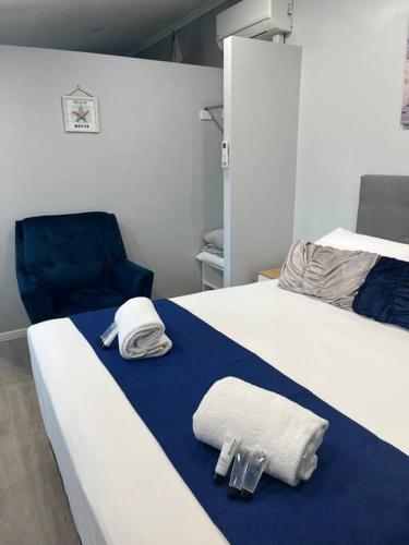 1 dormitorio con 2 camas, toallas y silla en Snapper Villa - Seaside, en Urangan