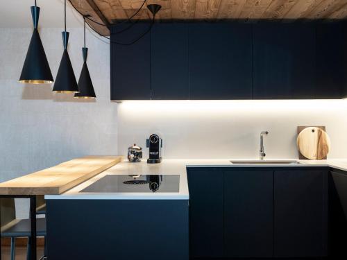- une cuisine avec des armoires bleu foncé et un évier dans l'établissement Duplex 4 chambres à Méribel, près du centre et des pistes, avec services de conciergerie - FR-1-613-47, à Les Allues