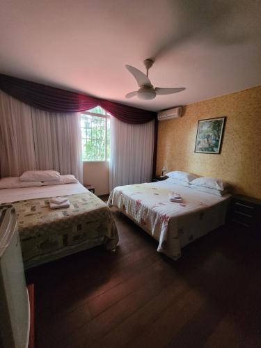 a bedroom with two beds and a ceiling fan at KzaZenDF CamaeCafé AsaSul in Brasilia