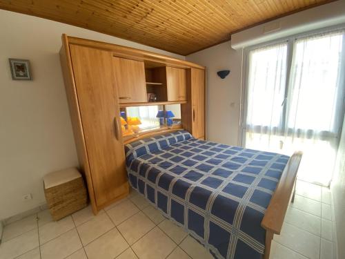 - une chambre avec un lit bleu et une fenêtre dans l'établissement Appartement Fouras, 3 pièces, 4 personnes - FR-1-709-37, à Fouras