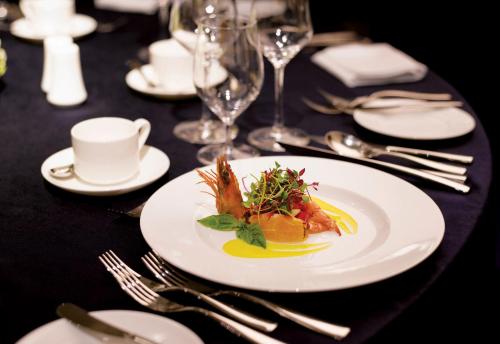 a table with a white plate with food on it at Holiday Inn Incheon Songdo by IHG in Incheon