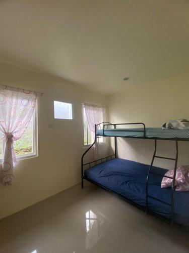 sypialnia z 2 łóżkami piętrowymi i oknem w obiekcie New 2 Bedroom Home w mieście Cagayan de Oro