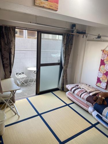 Habitación con cama y puerta corredera de cristal en 東洋の家-畳み部屋小庭園, en Tokio