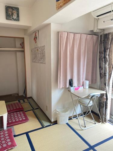 Habitación pequeña con mesa y ventana en 東洋の家-畳み部屋小庭園, en Tokio