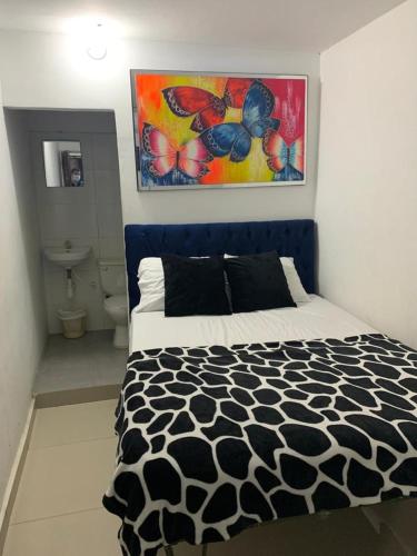 a bedroom with a black and white bed and a bathroom at Costa atlantico in Barranquilla